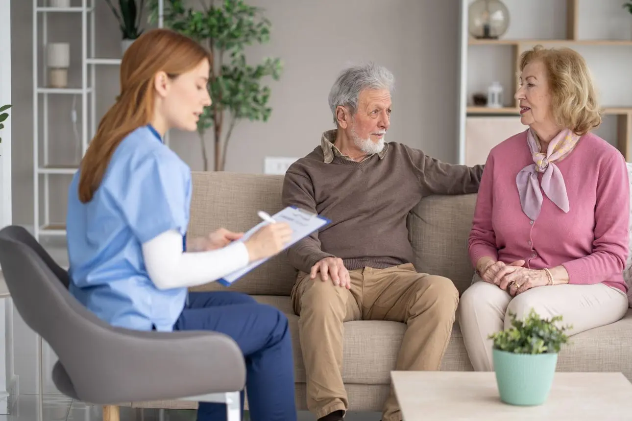 A nurse meets with a senior couple at home to discuss care options.